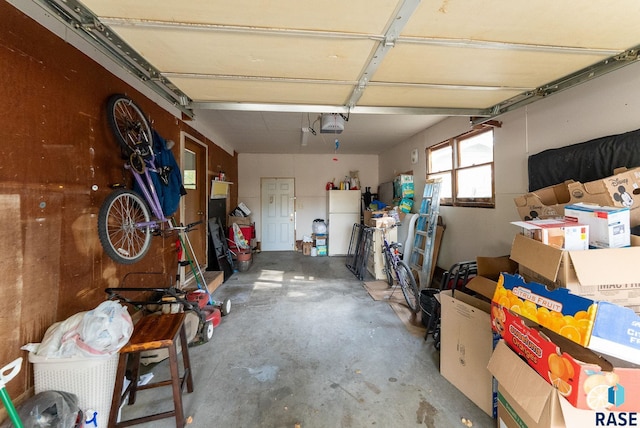 garage with a garage door opener and white refrigerator