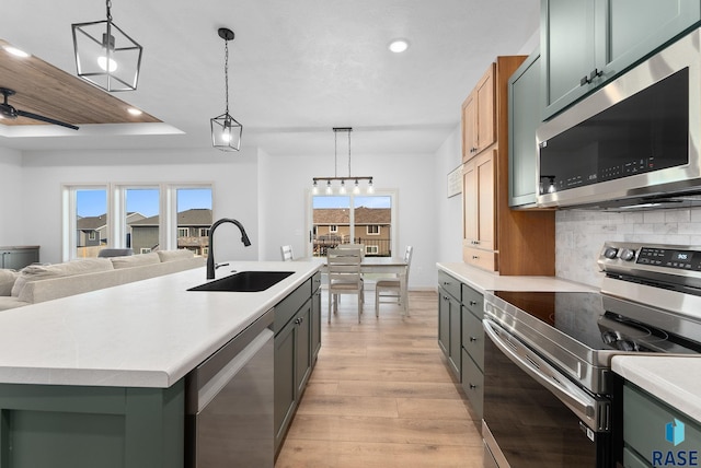 kitchen with plenty of natural light, sink, stainless steel appliances, and an island with sink