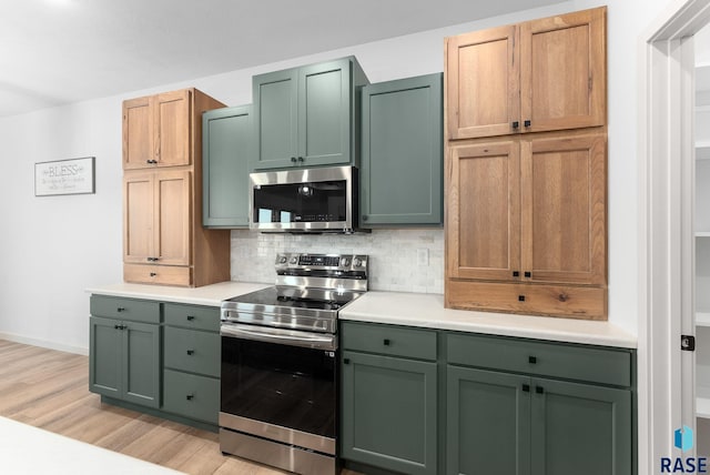 kitchen with tasteful backsplash, stainless steel appliances, light brown cabinets, light hardwood / wood-style flooring, and green cabinets