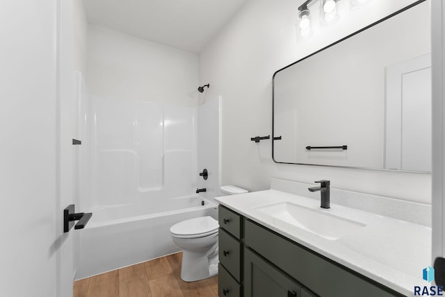 full bathroom with hardwood / wood-style floors, vanity, toilet, and shower / washtub combination