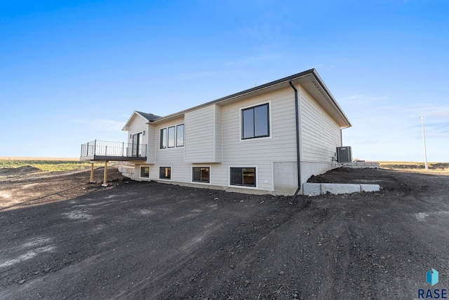 view of home's exterior with a wooden deck and central AC