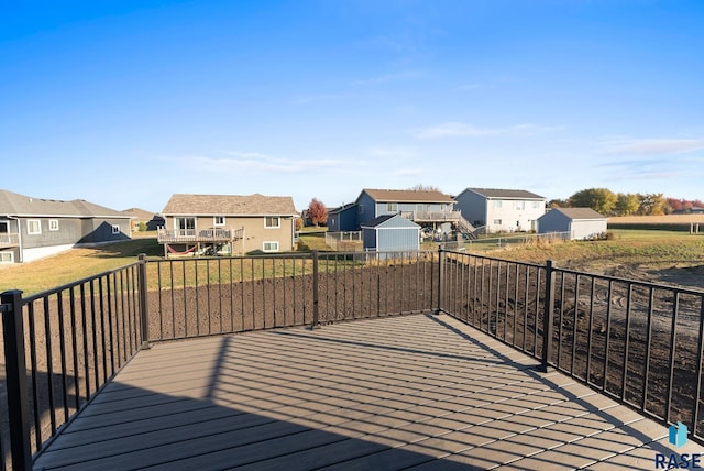 wooden terrace with a yard and a shed