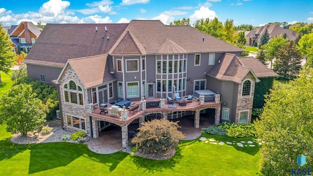 rear view of property with a patio area, a wooden deck, and a lawn