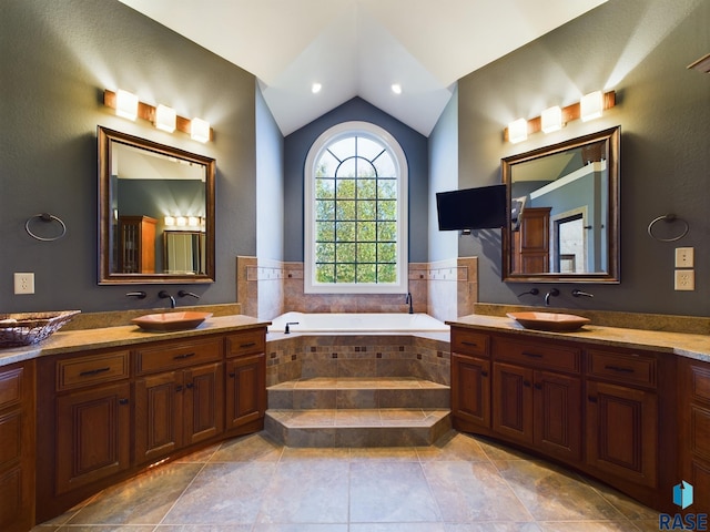 bathroom with vanity, tiled bath, tile patterned floors, and lofted ceiling