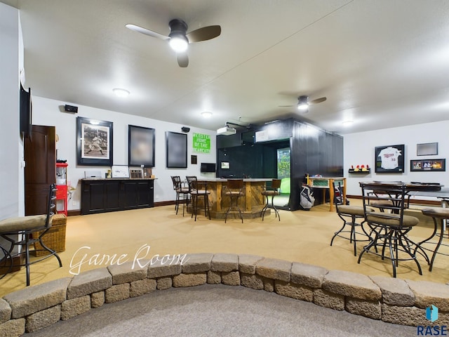 dining space with ceiling fan, carpet floors, and bar area