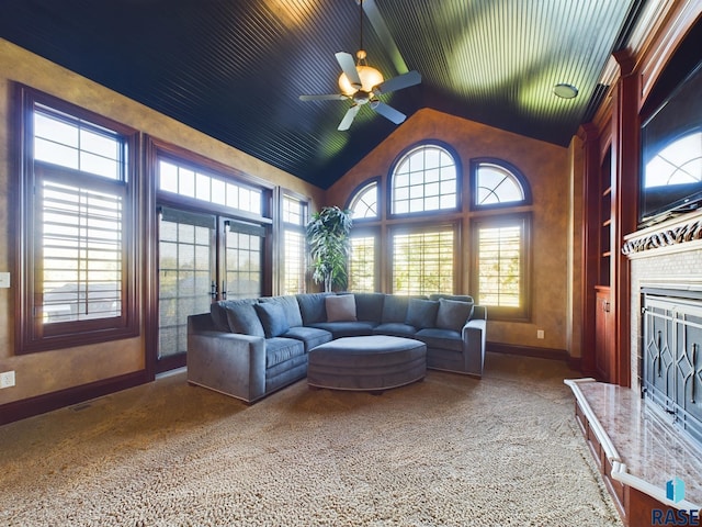 living room with ceiling fan, carpet flooring, lofted ceiling, and a high end fireplace