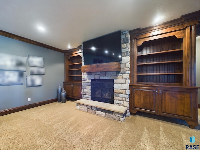 unfurnished living room with crown molding, a stone fireplace, and light colored carpet