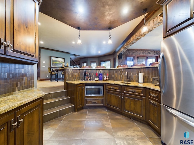 kitchen with kitchen peninsula, a healthy amount of sunlight, stainless steel appliances, and pendant lighting