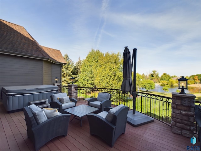 wooden terrace with a hot tub, an outdoor hangout area, and a water view