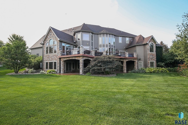 rear view of house featuring a wooden deck and a yard