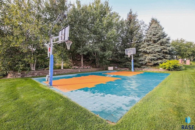 view of sport court with a lawn