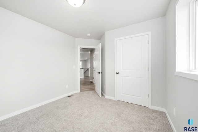 unfurnished bedroom with light colored carpet