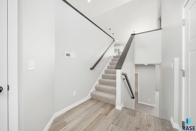 staircase with hardwood / wood-style floors