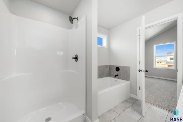 bathroom featuring independent shower and bath, tile patterned floors, and vaulted ceiling