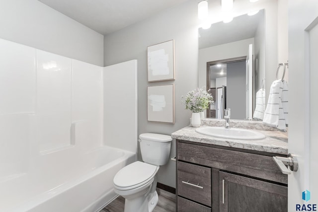 full bathroom with hardwood / wood-style flooring, vanity, shower / bath combination, and toilet