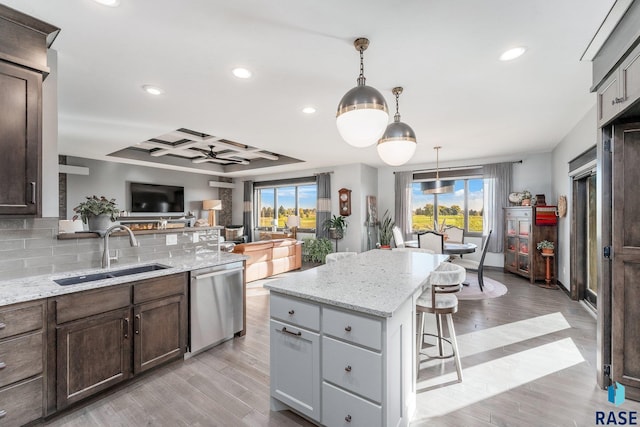 kitchen featuring a kitchen island, sink, dishwasher, and light hardwood / wood-style floors