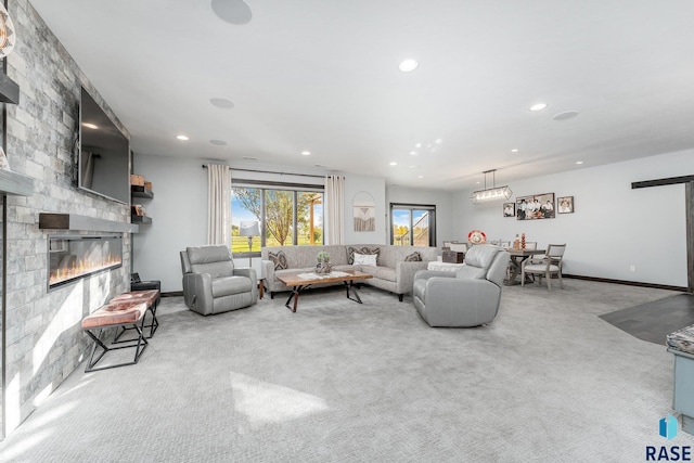 carpeted living room with a stone fireplace