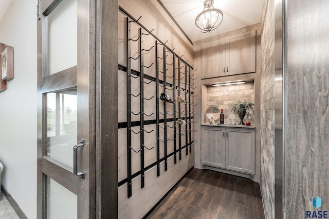 wine cellar with a chandelier and dark hardwood / wood-style flooring