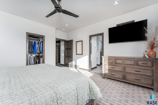 carpeted bedroom featuring a closet, ceiling fan, and a walk in closet