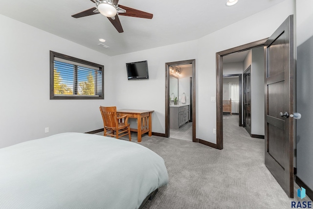 bedroom with ensuite bath, light carpet, and ceiling fan