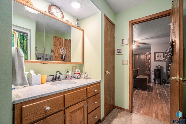 bathroom featuring vanity, ceiling fan, a textured ceiling, and hardwood / wood-style floors