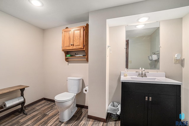 bathroom featuring vanity, hardwood / wood-style flooring, and toilet