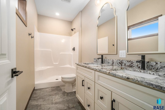 bathroom featuring a shower, vanity, and toilet