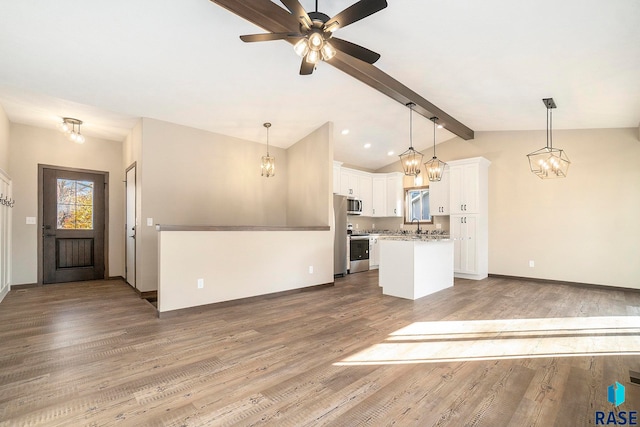 unfurnished living room featuring wood-type flooring, lofted ceiling with beams, ceiling fan, and sink