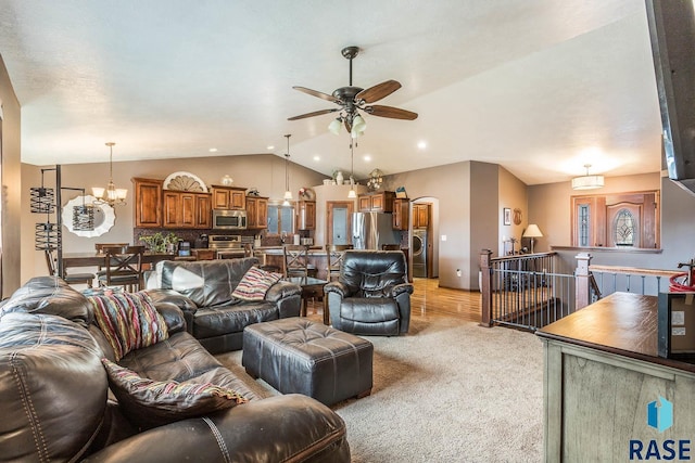 living room featuring lofted ceiling, light hardwood / wood-style floors, and ceiling fan with notable chandelier