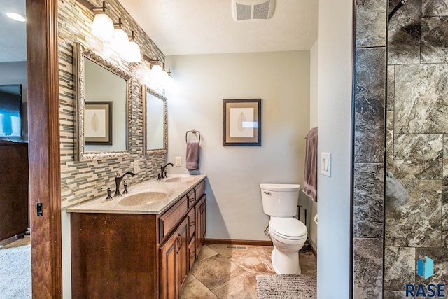 bathroom with vanity, decorative backsplash, a textured ceiling, and toilet