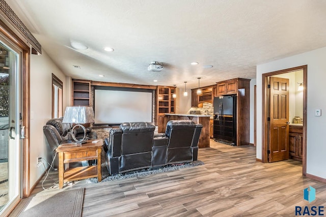 home theater featuring a textured ceiling and light hardwood / wood-style floors