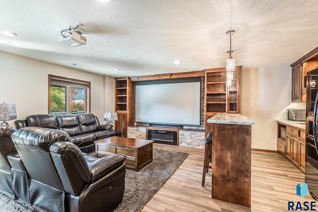 living room with a textured ceiling and light hardwood / wood-style flooring