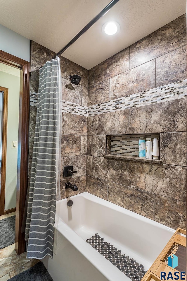 bathroom featuring a textured ceiling and shower / tub combo