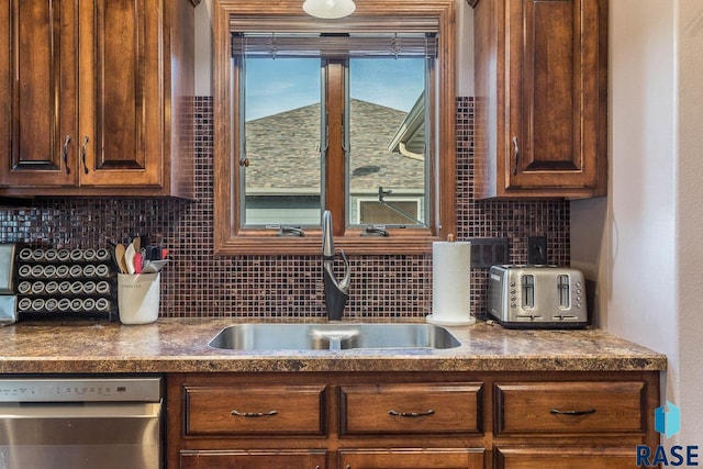 kitchen featuring stainless steel dishwasher, sink, and decorative backsplash