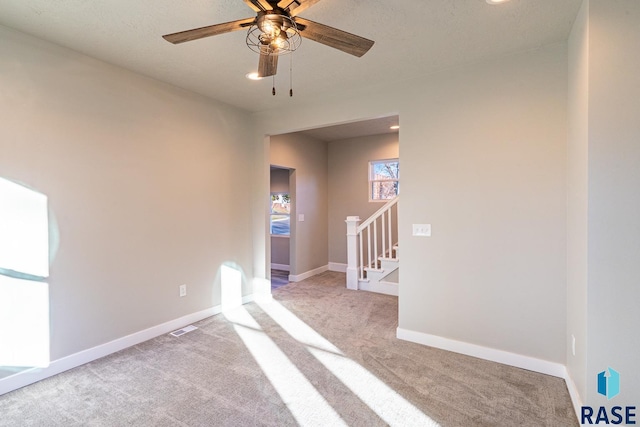 carpeted spare room with ceiling fan