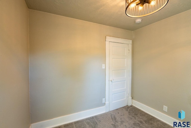 empty room with a textured ceiling and carpet flooring