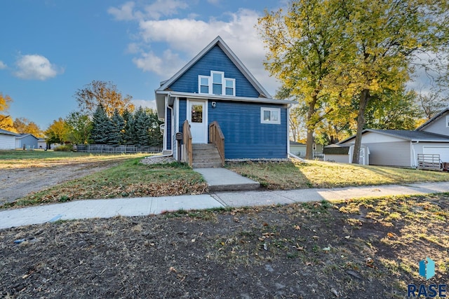 view of front of home with a garage and an outbuilding