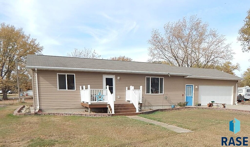 208 5th St, Hudson, SD 57034 - ranch-style house featuring a front lawn, driveway, and an attached garage