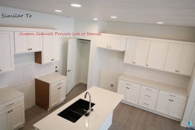 kitchen with white cabinets, hardwood / wood-style flooring, and backsplash