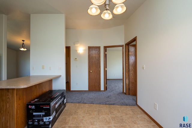 kitchen with kitchen peninsula and light colored carpet