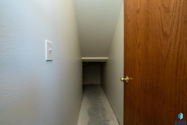 stairway featuring concrete flooring and vaulted ceiling