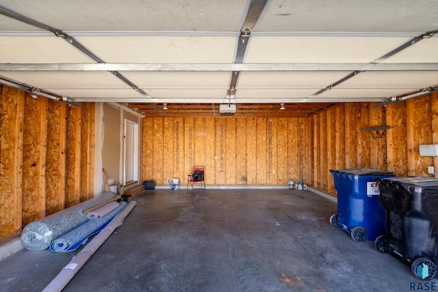 garage with wood walls and a garage door opener