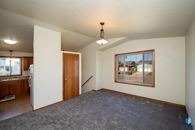 interior space with dark colored carpet, plenty of natural light, and lofted ceiling