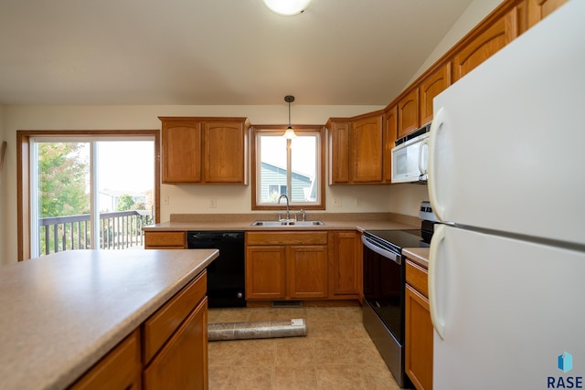 kitchen featuring black appliances, decorative light fixtures, a wealth of natural light, and sink