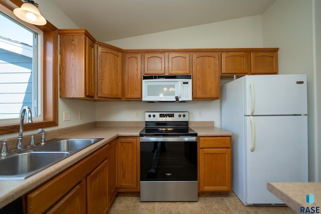 kitchen featuring lofted ceiling, sink, white appliances, and light tile patterned floors