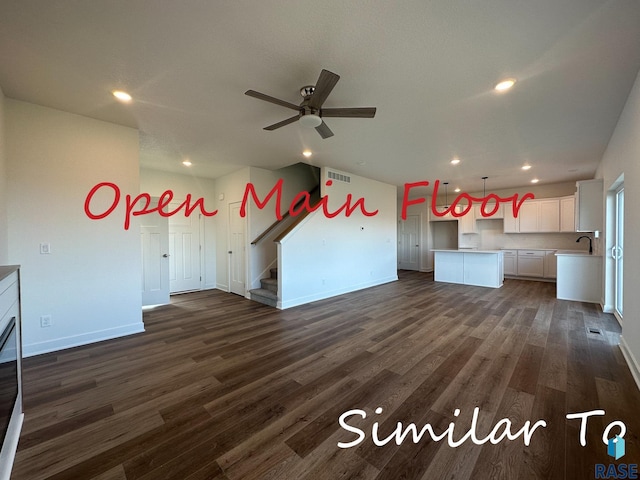 unfurnished living room with sink, dark wood-type flooring, and ceiling fan