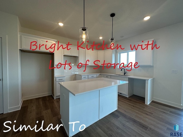 kitchen with pendant lighting, white cabinets, a kitchen island, dark hardwood / wood-style flooring, and sink