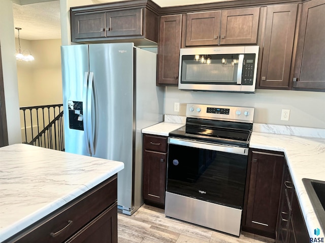 kitchen featuring a chandelier, dark brown cabinetry, stainless steel appliances, and light hardwood / wood-style flooring