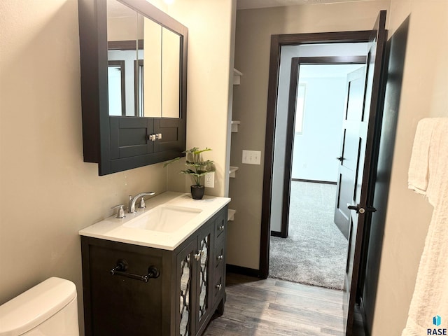 bathroom featuring hardwood / wood-style floors, vanity, and toilet