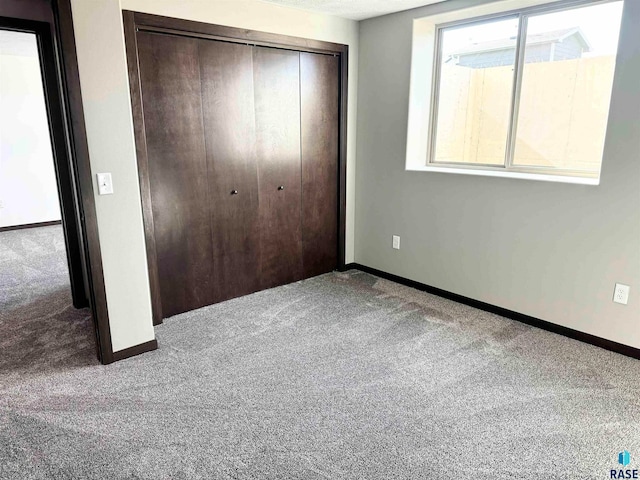 unfurnished bedroom with a closet and carpet